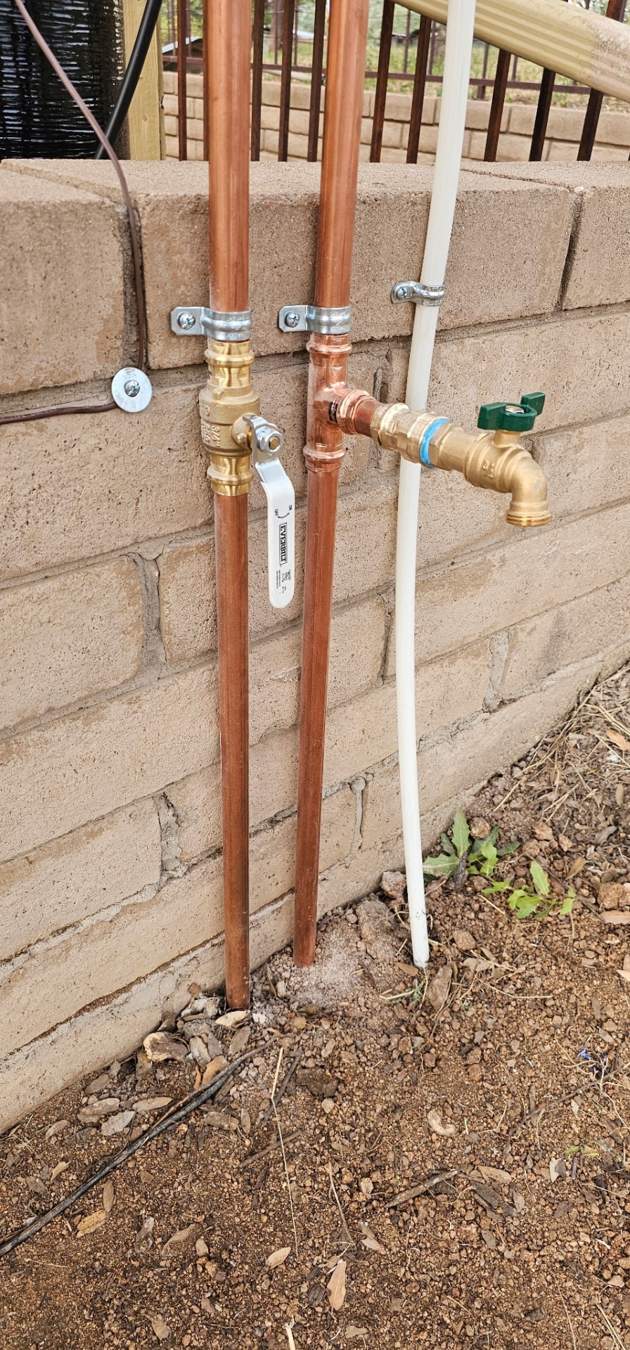 Outdoor copper bypass with brass shutoff valves and hose bib on a side-yard install