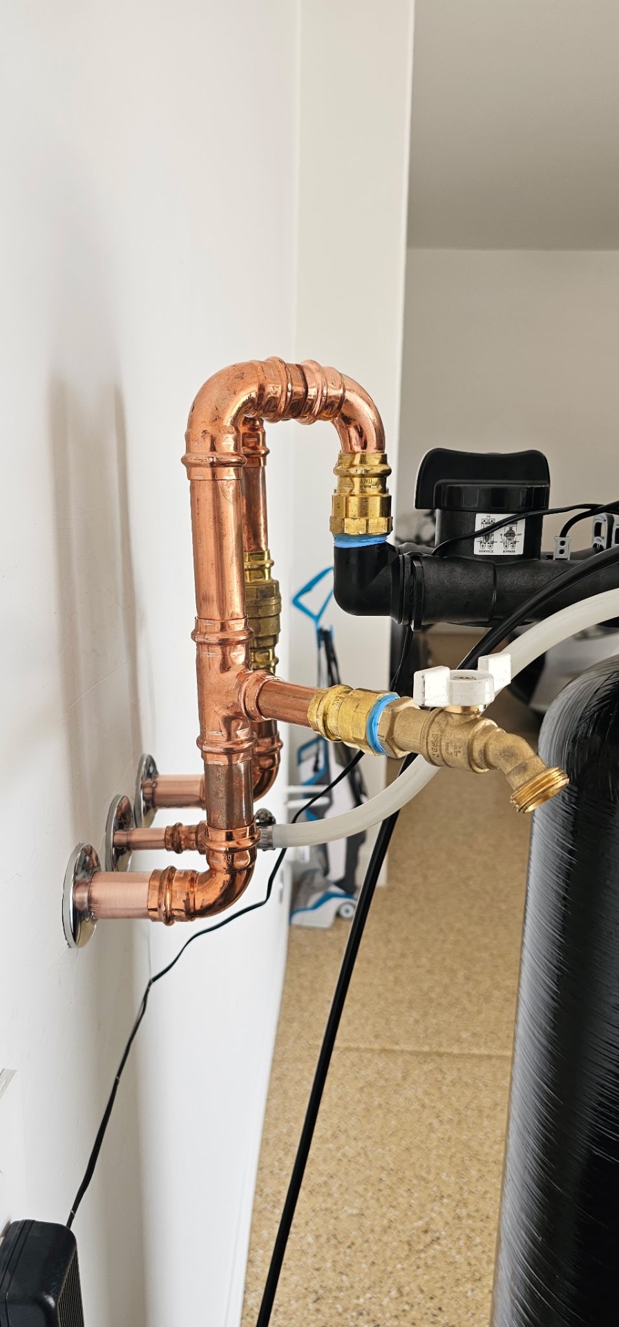 Close-up of clean copper bypass plumbing and brass shutoff valves on a softener install