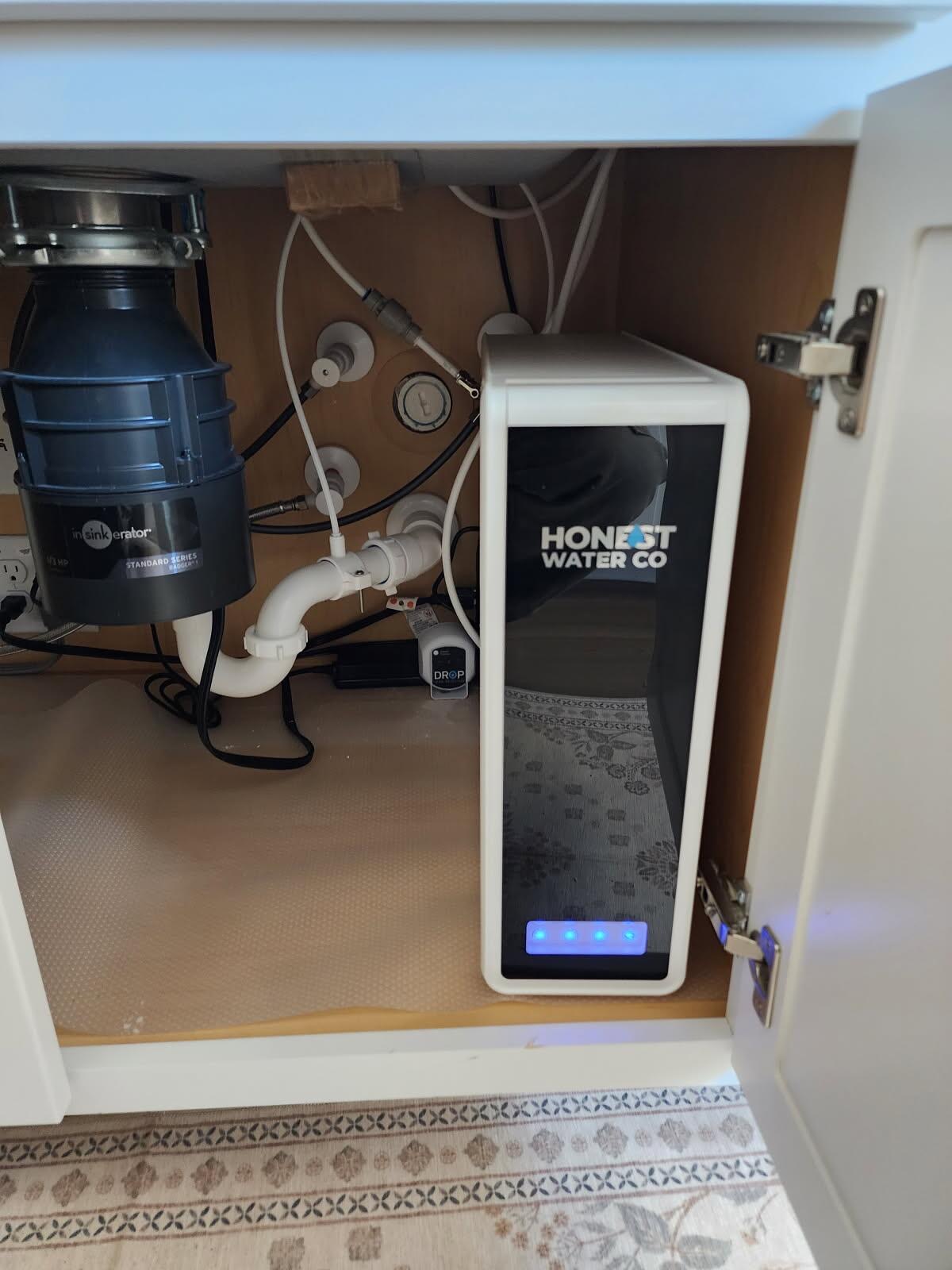 Under-sink tankless reverse osmosis system installed in a kitchen cabinet