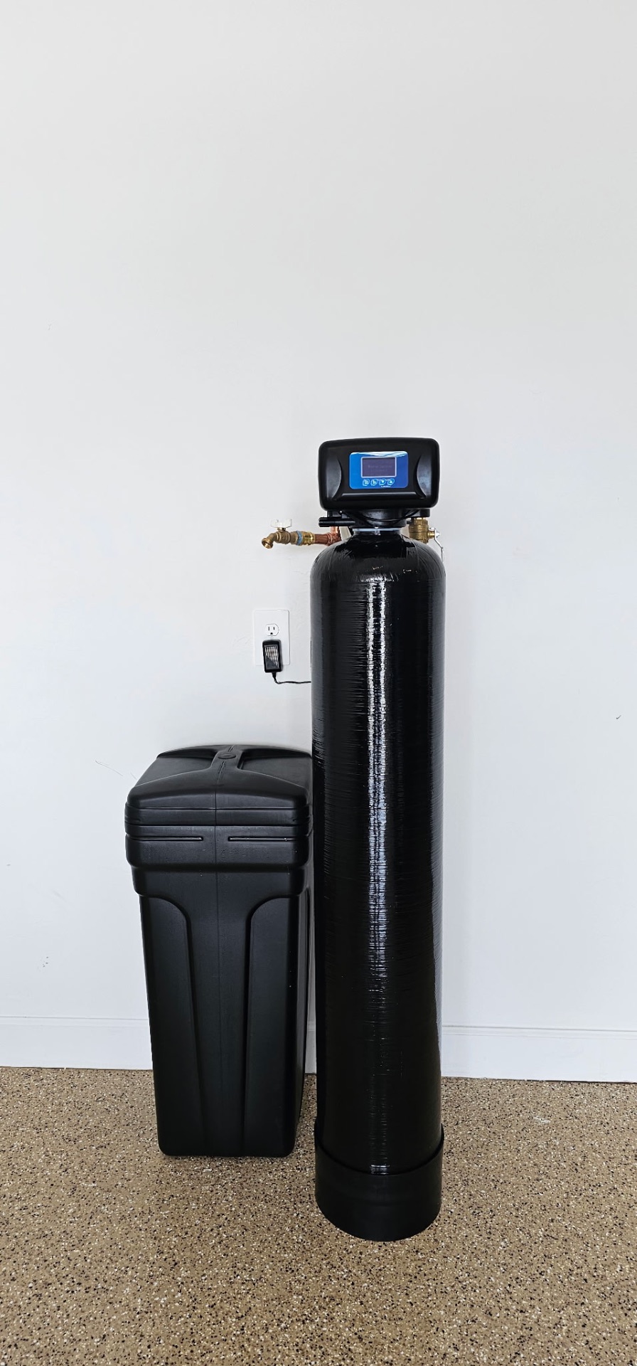 Single tank whole-home water softener and brine tank installed against a garage wall