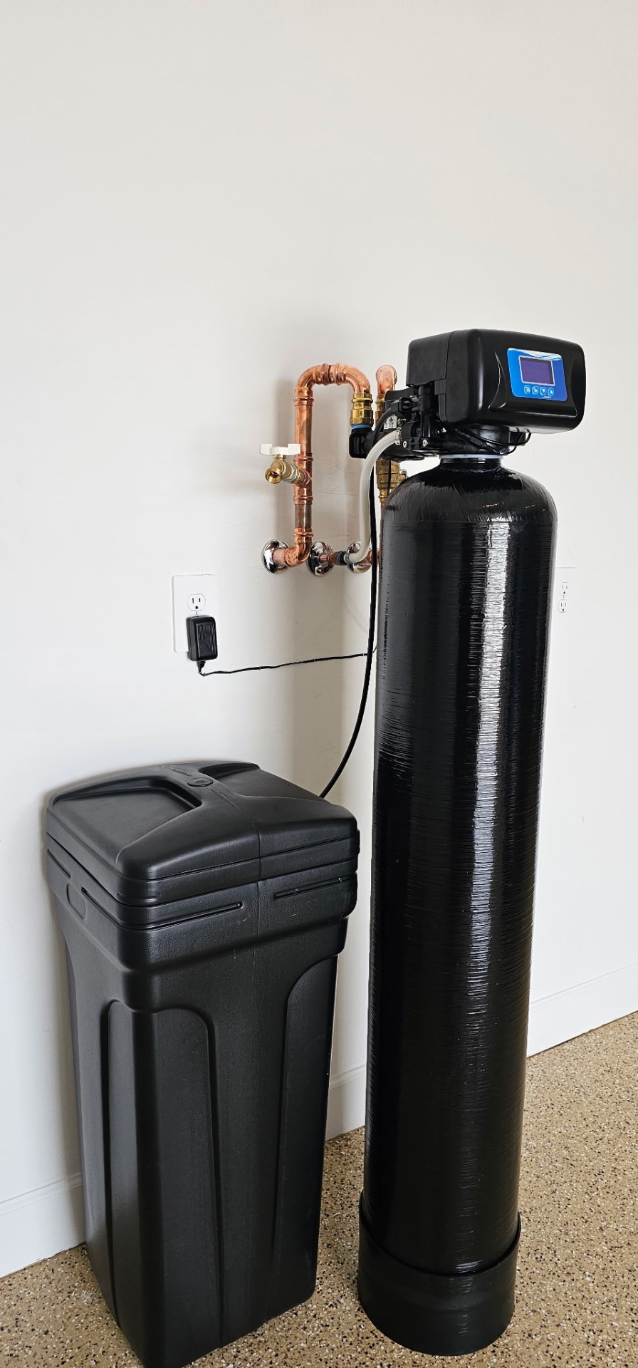 Whole-home softener with copper bypass loop and brine tank installed in a garage corner