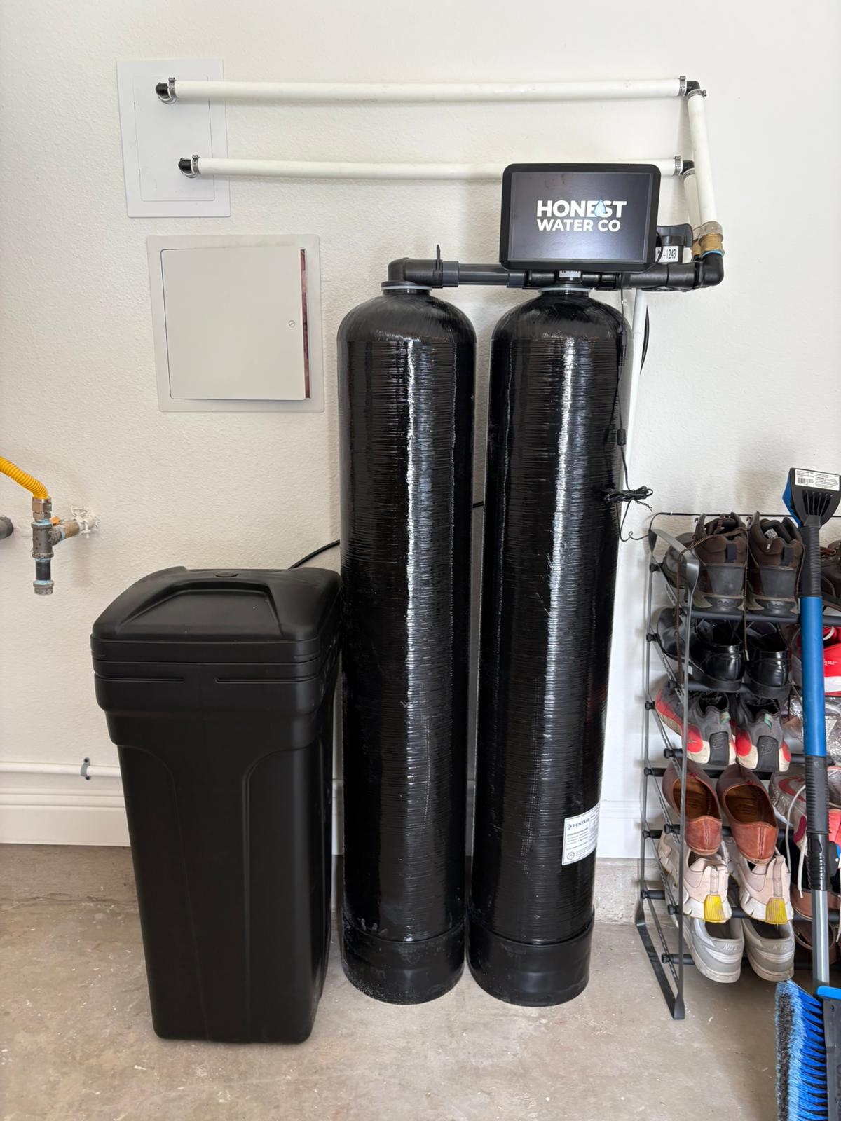 Whole-home water treatment system plumbed into a garage water loop