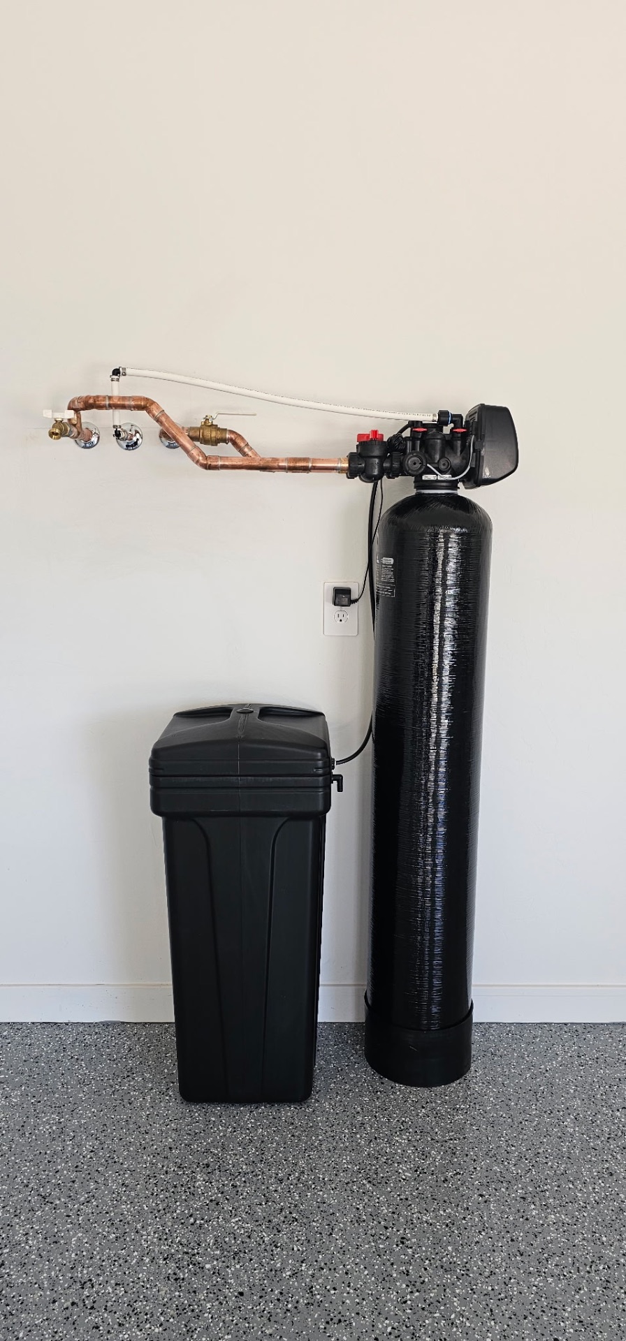 Whole-home softener with digital valve and brine tank plumbed with copper in a garage