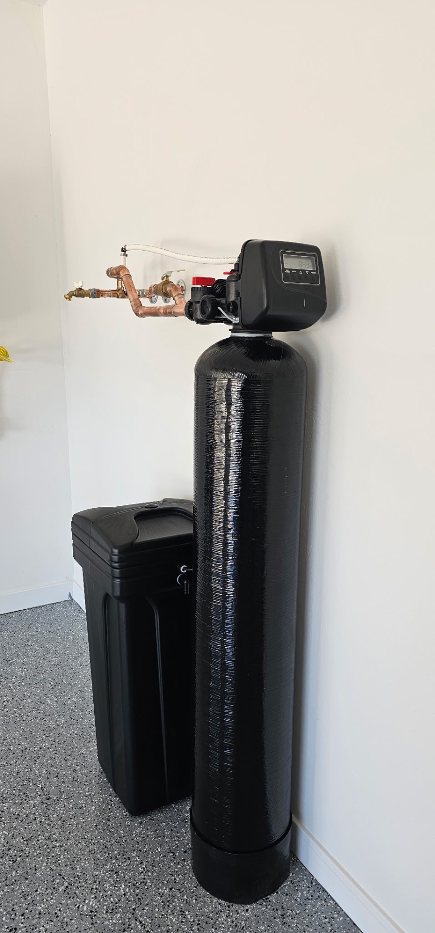 Whole-home softener and brine tank installed in a corner with copper bypass plumbing