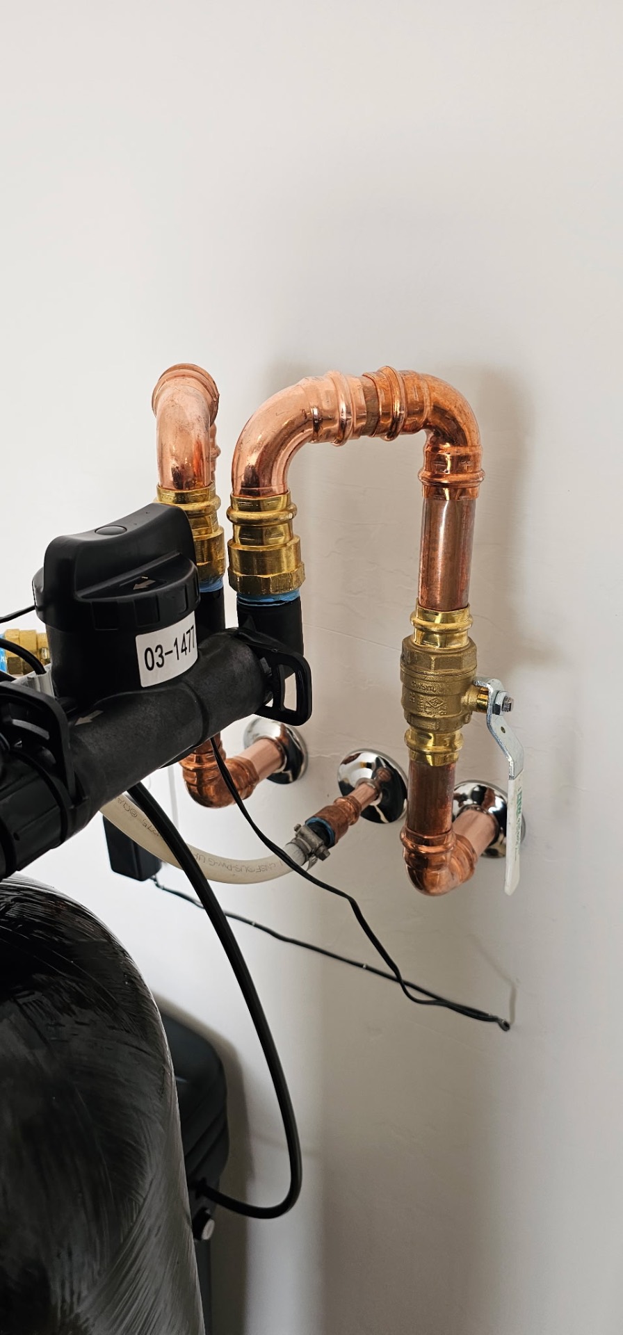 Close-up of polished copper bypass plumbing with brass valves and union fittings